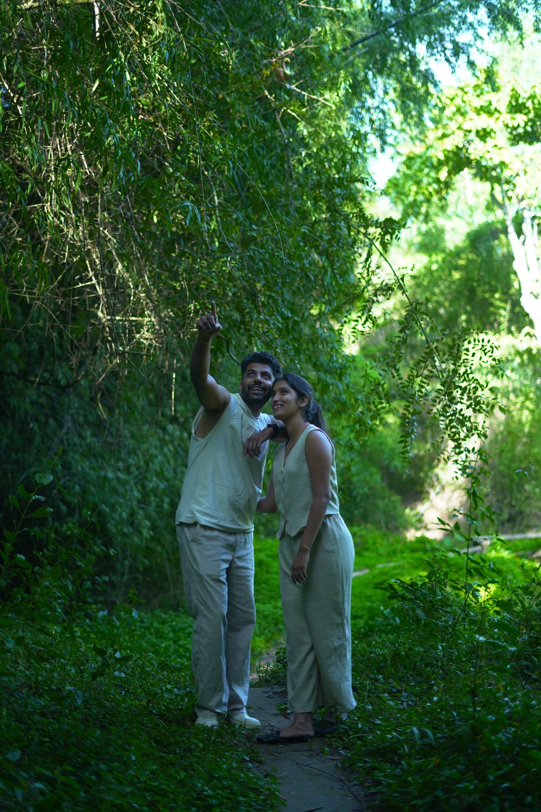 A couple pointing out something on a green forest trail